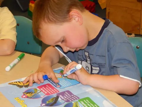 a young boy coloring on a paper