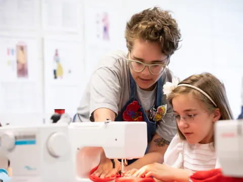 a person and a girl looking at a computer