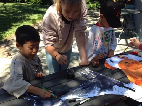 a person and two children painting