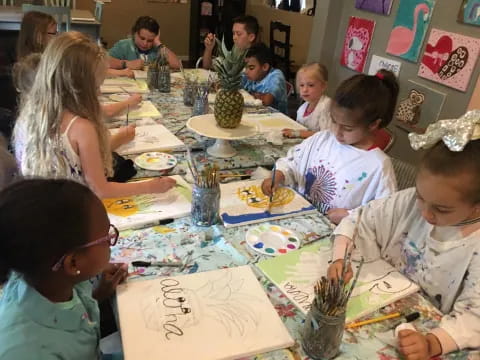 a group of children sitting at a table eating food