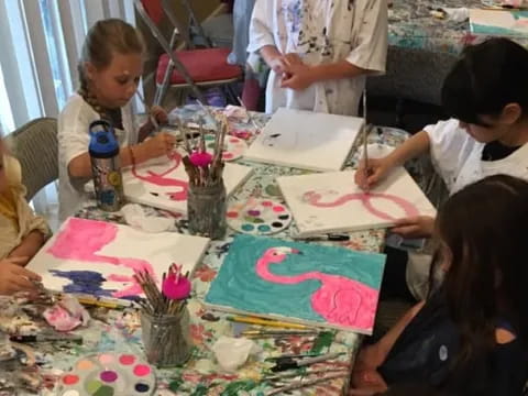 a group of children sitting at a table with colorful paper on it