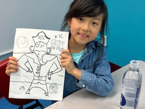 a girl holding a drawing