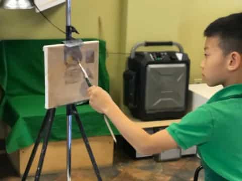 a boy painting a picture