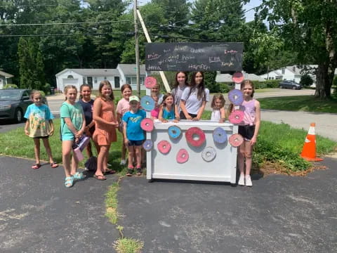 a group of people posing for a photo with a sign