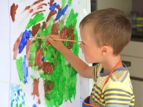 a child painting on a white board