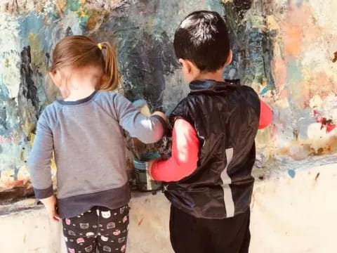 a boy and girl looking at a painting