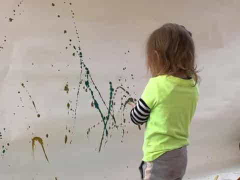 a girl drawing on a white wall