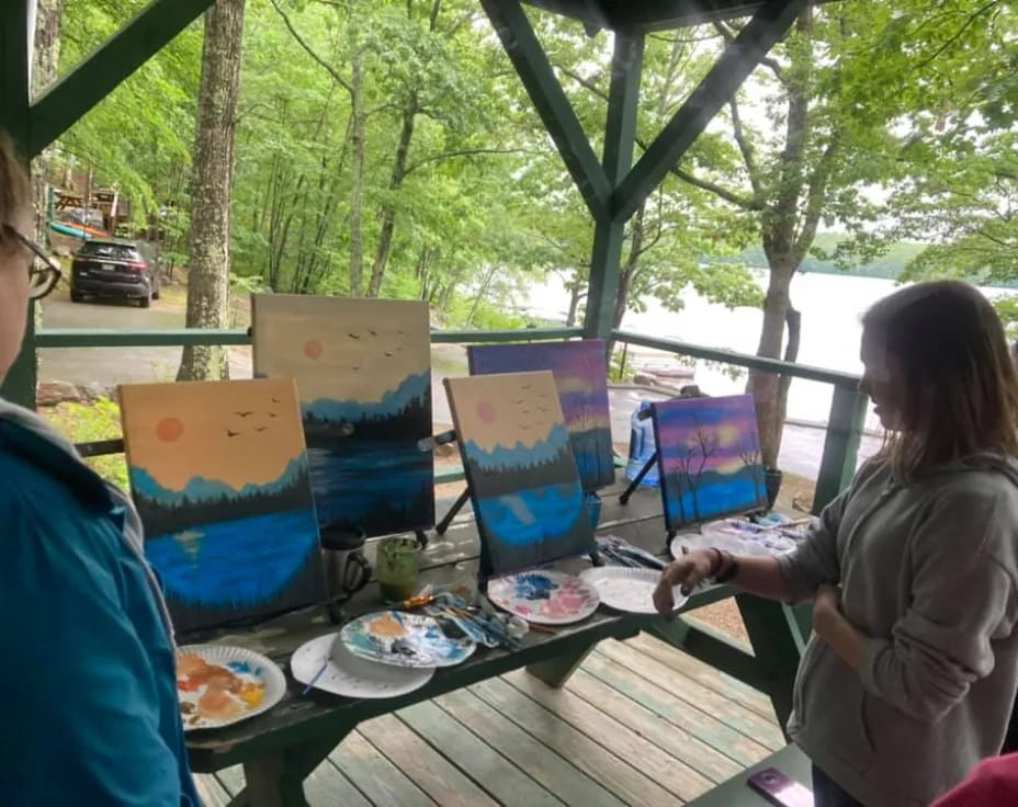 a couple of people sitting at a picnic table with food and drinks