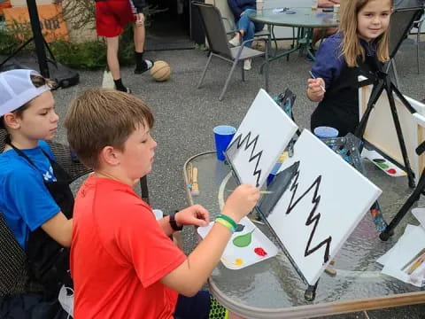 a group of children sitting at a table with a drawing