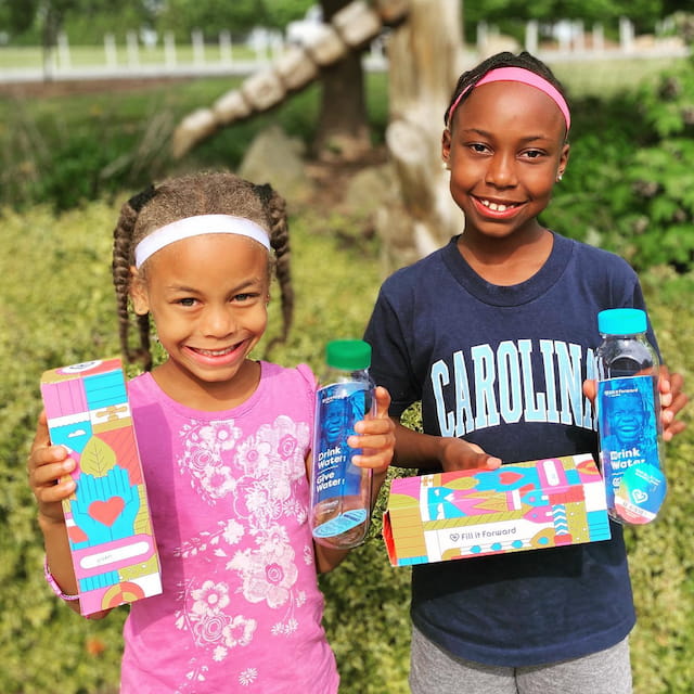 a couple of girls holding water bottles