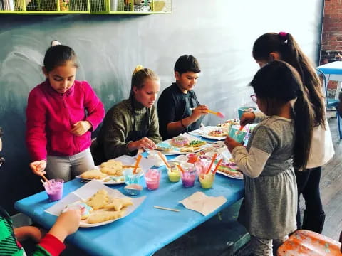 a group of people sitting at a table with food