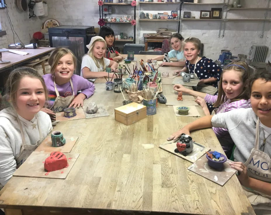 a group of children sitting at a table with toys