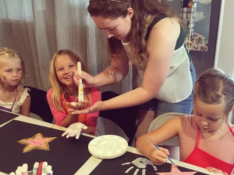 a woman helping a group of kids