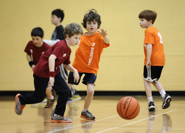 a group of kids playing basketball