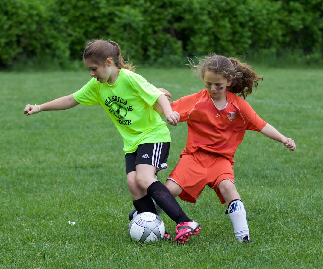 girls playing football on a field