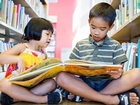 a boy and girl reading a book