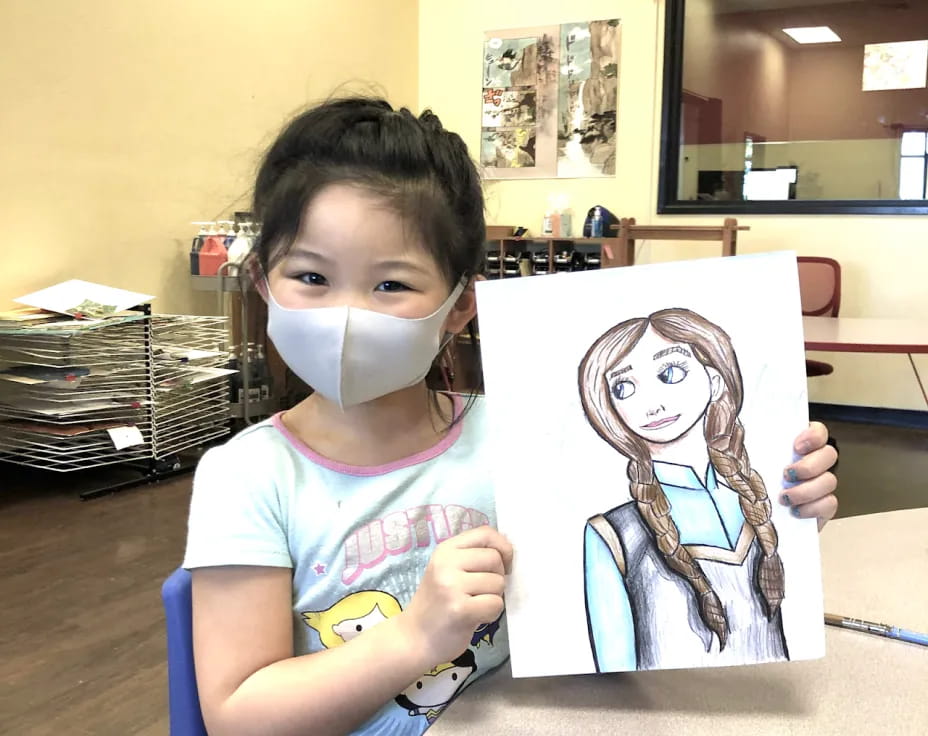 a girl holding a drawing