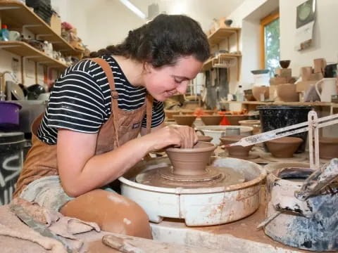 a woman making clay pots