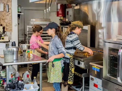 a group of people cooking in a kitchen