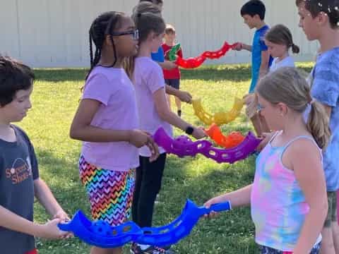a group of children playing with a colorful ribbon