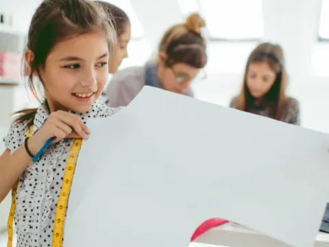 a young girl smiling at a computer