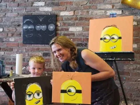 a person sitting at a table with a couple of cartoon faces