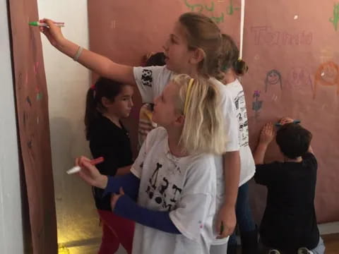 a group of young girls writing on a whiteboard