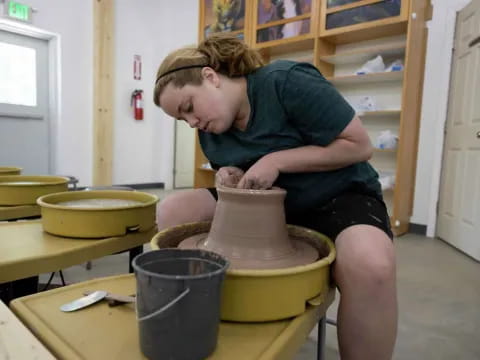 a person making a clay pot