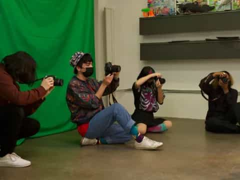 a group of people sitting on the floor with cameras