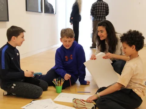 a group of people sitting on the floor looking at papers