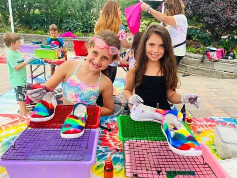 a couple of girls sitting at a table with a birthday cake