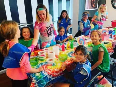 a group of children sitting around a table with food on it