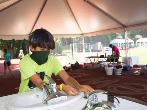 a young boy washing his hands