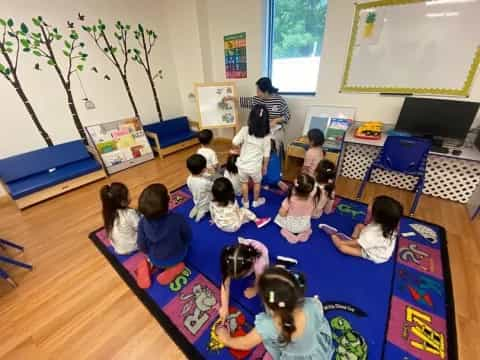 a group of children sitting on the floor in a classroom