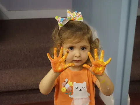 a little girl with a crown and a toy in her hand