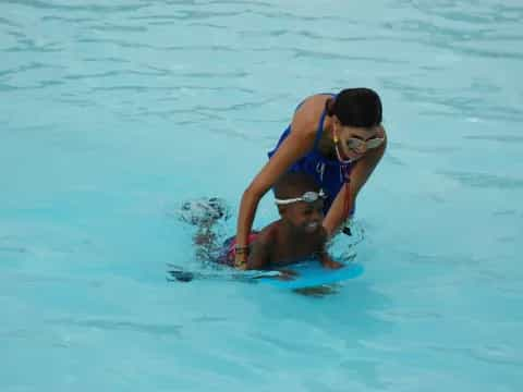 a man and woman on a surfboard in the water