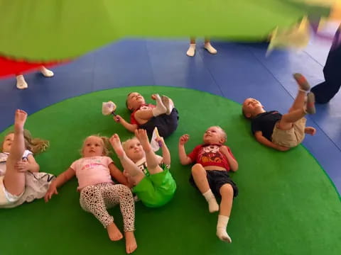a group of children on a green mat