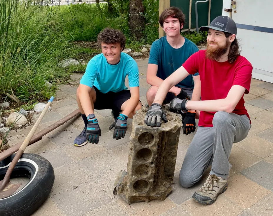 a group of people sitting on a stump with a tire and a wheel