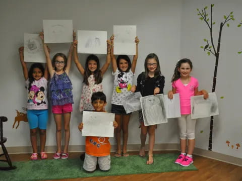 a group of girls holding up papers