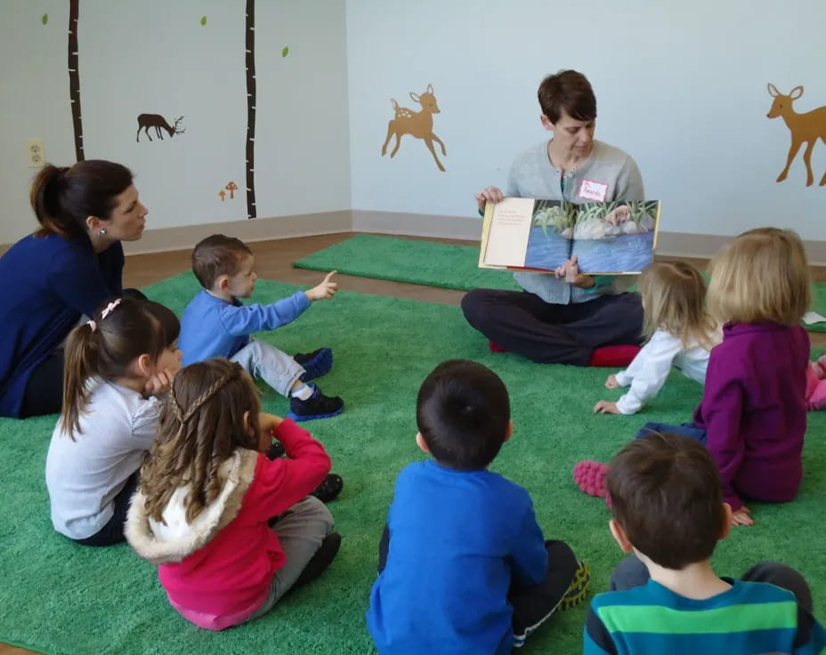 a person reading a book to a group of children