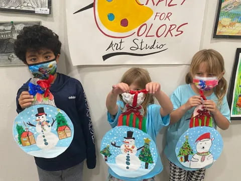 a group of children holding up artwork