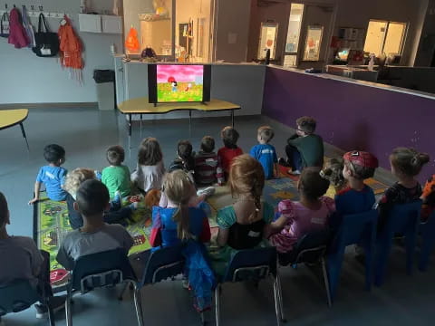 a group of children watching a television