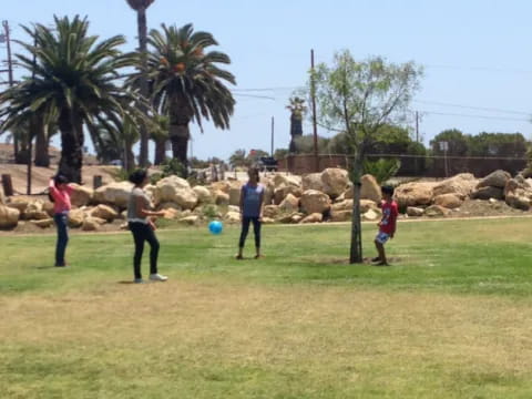 a group of people playing with a ball in a field