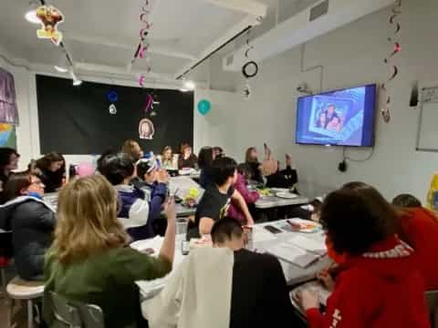 a group of people sitting at tables watching a presentation