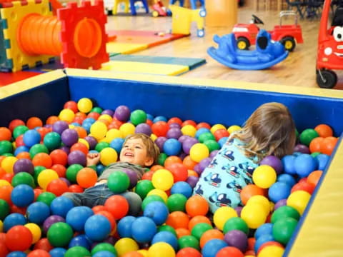 a child playing in a ball pit