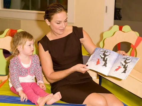 a person and a child sitting on a bed