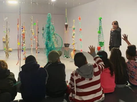 a group of people sitting in a room with christmas trees