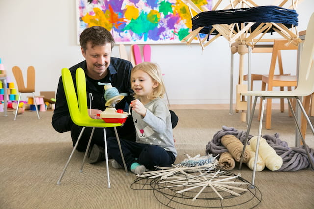 a person and a girl sitting in a room with a table and chairs