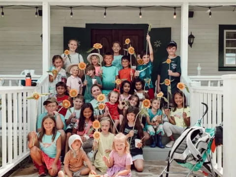 a group of people posing for a photo in front of a house