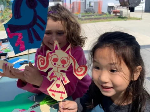 a couple of girls holding up a sign